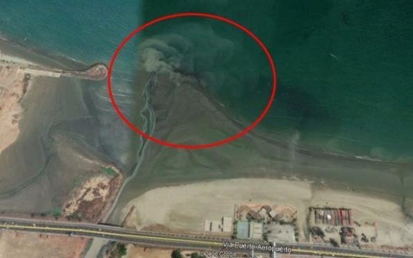 Figura 4: Obsérvese la desembocadura del río Muerto en la playa. La presencia de sedimentos en suspensión y desechos contaminantes se puede apreciar con claridad en esta imagen (círculo rojo).